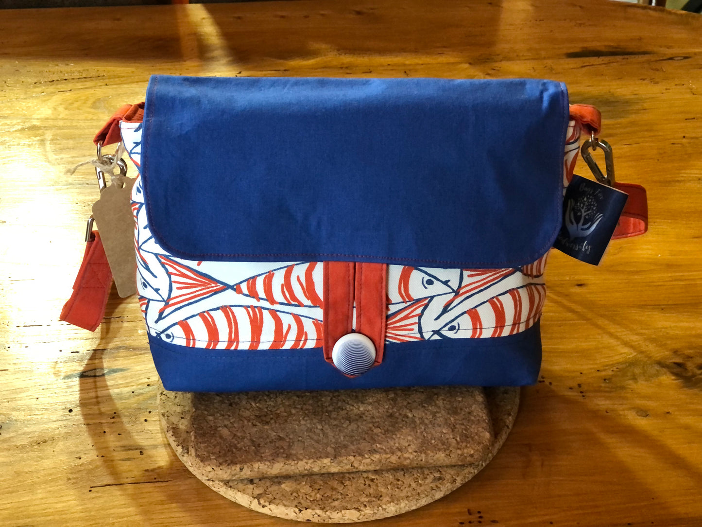 orange blue and white fish shoulder bag with button fastening