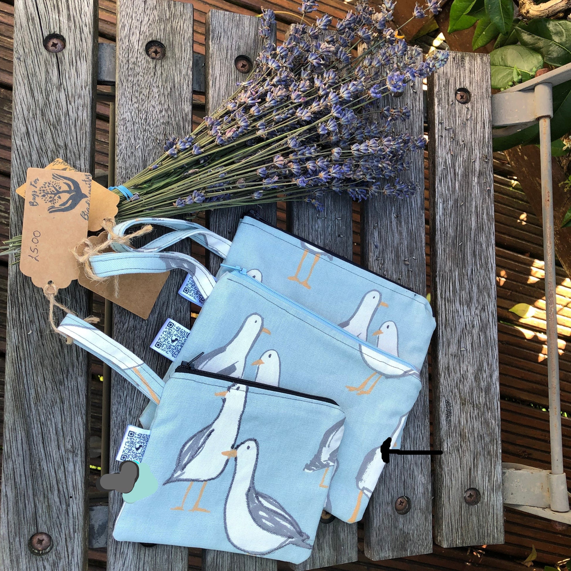 picture shows three cosmetic bags . The bag described is the smallest of the 3 , with the dark grey zip 